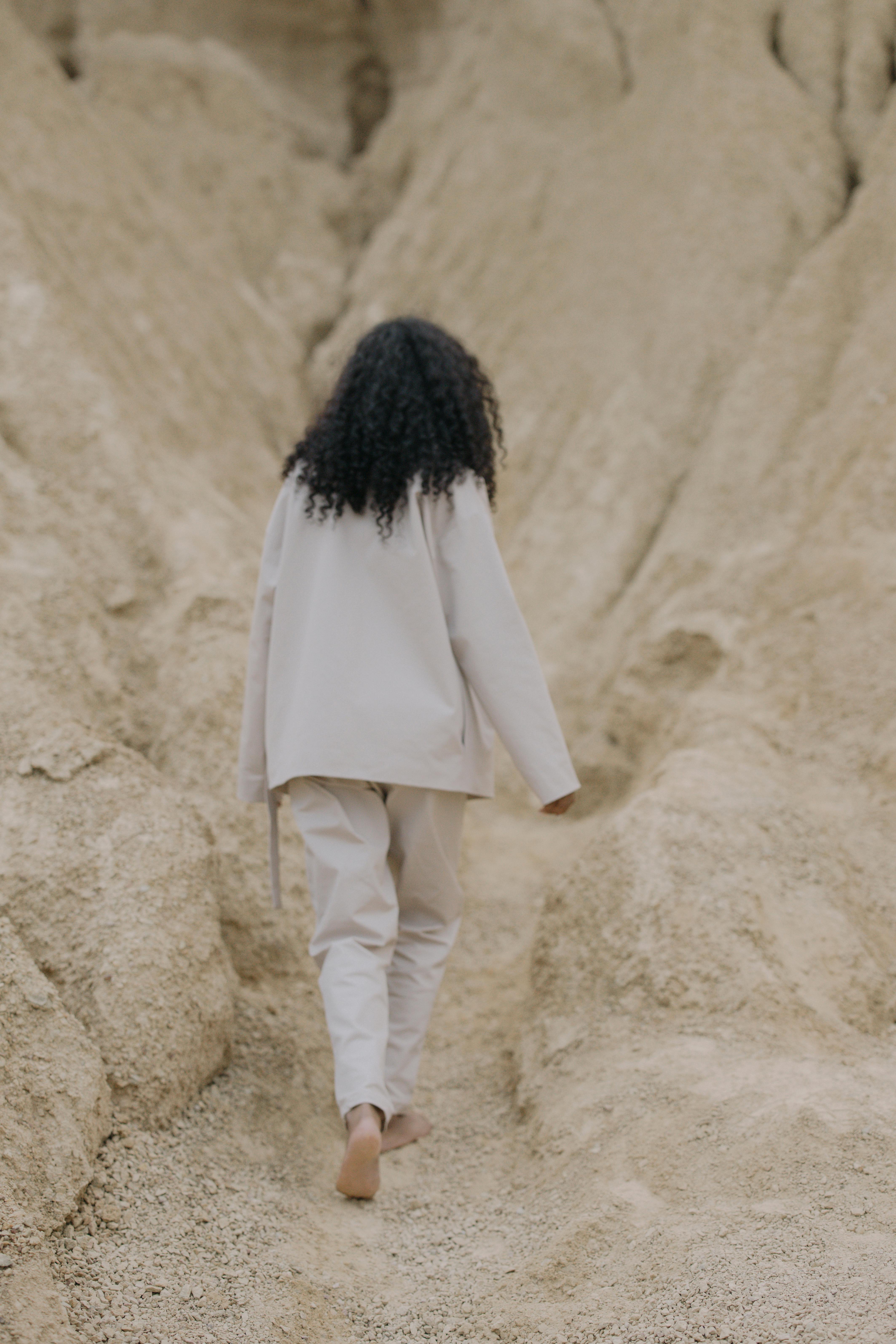Person Walking Barefooted on Brown Sand